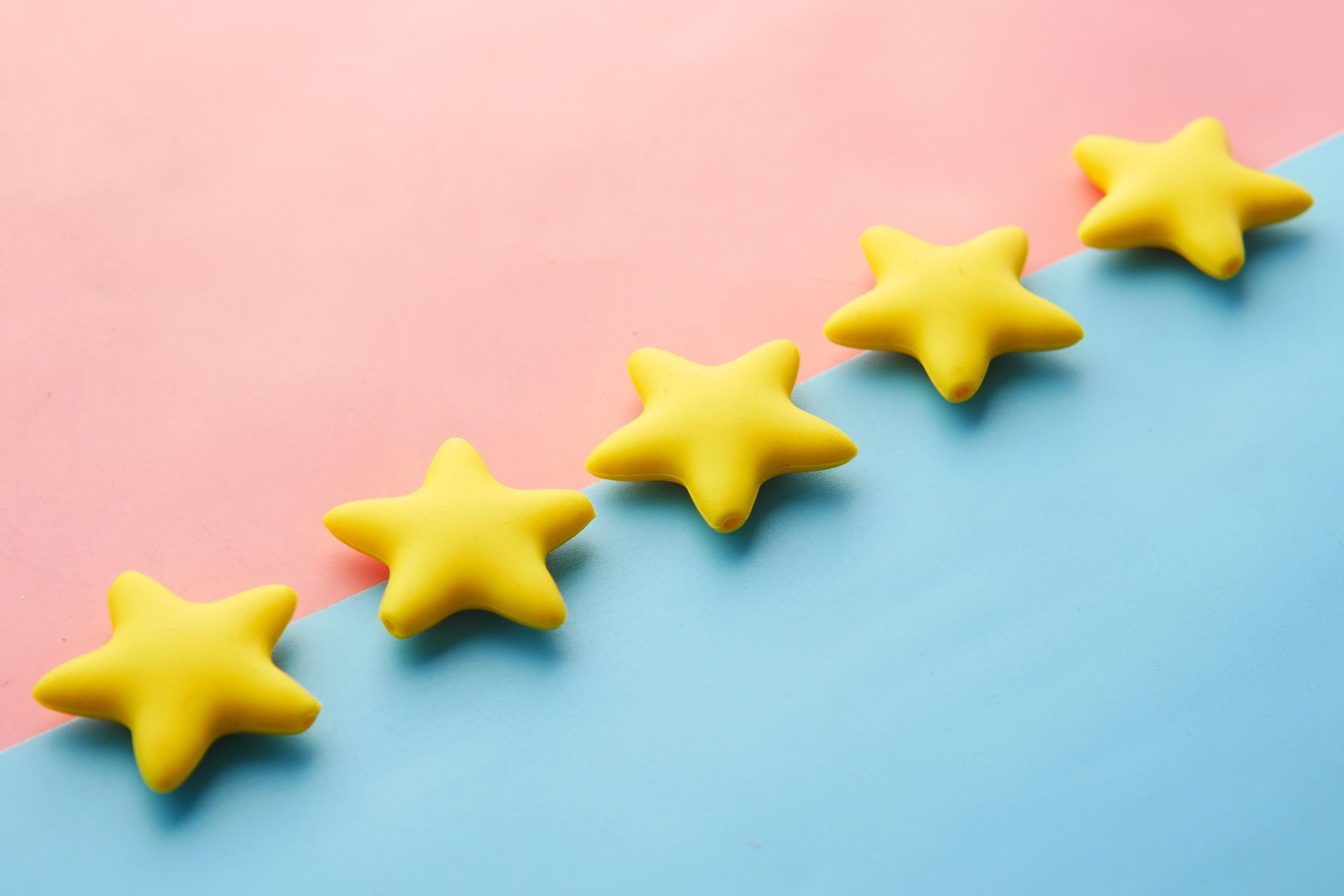 Image shows five gold stars against in the middle of a pink and blue background