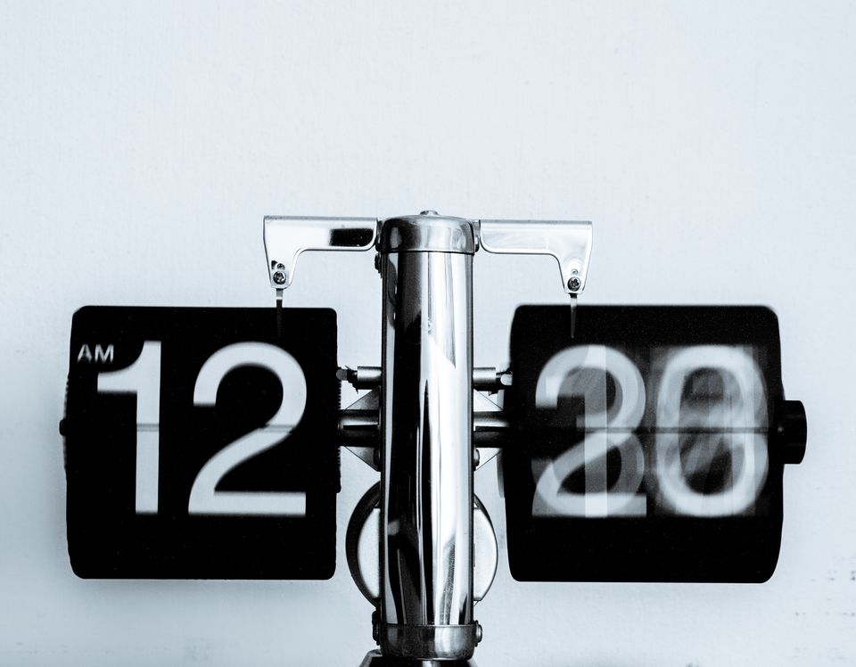 Image shows a black clock with while numbers 